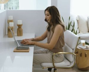 Dr Courtney Stewart working on laptop in a calm space - representing self-paced masterclasses on skin, gut, and hormone health